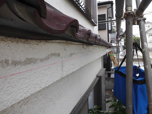 水平器を使って雨樋の勾配を確認している様子