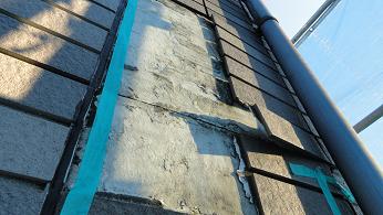 外壁タイルが複数枚剥落している状態。下地サイディングが露出し、壁全体が不安定になっている