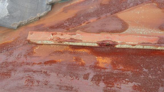 瓦屋根と板金屋根の取り合い部分の谷。板金が腐食してほぼ消失し、下地が露出している状態